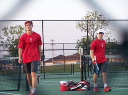 one doubles team comes back to the fence to discuss doubles strategy with Head Coach Curt Roehm